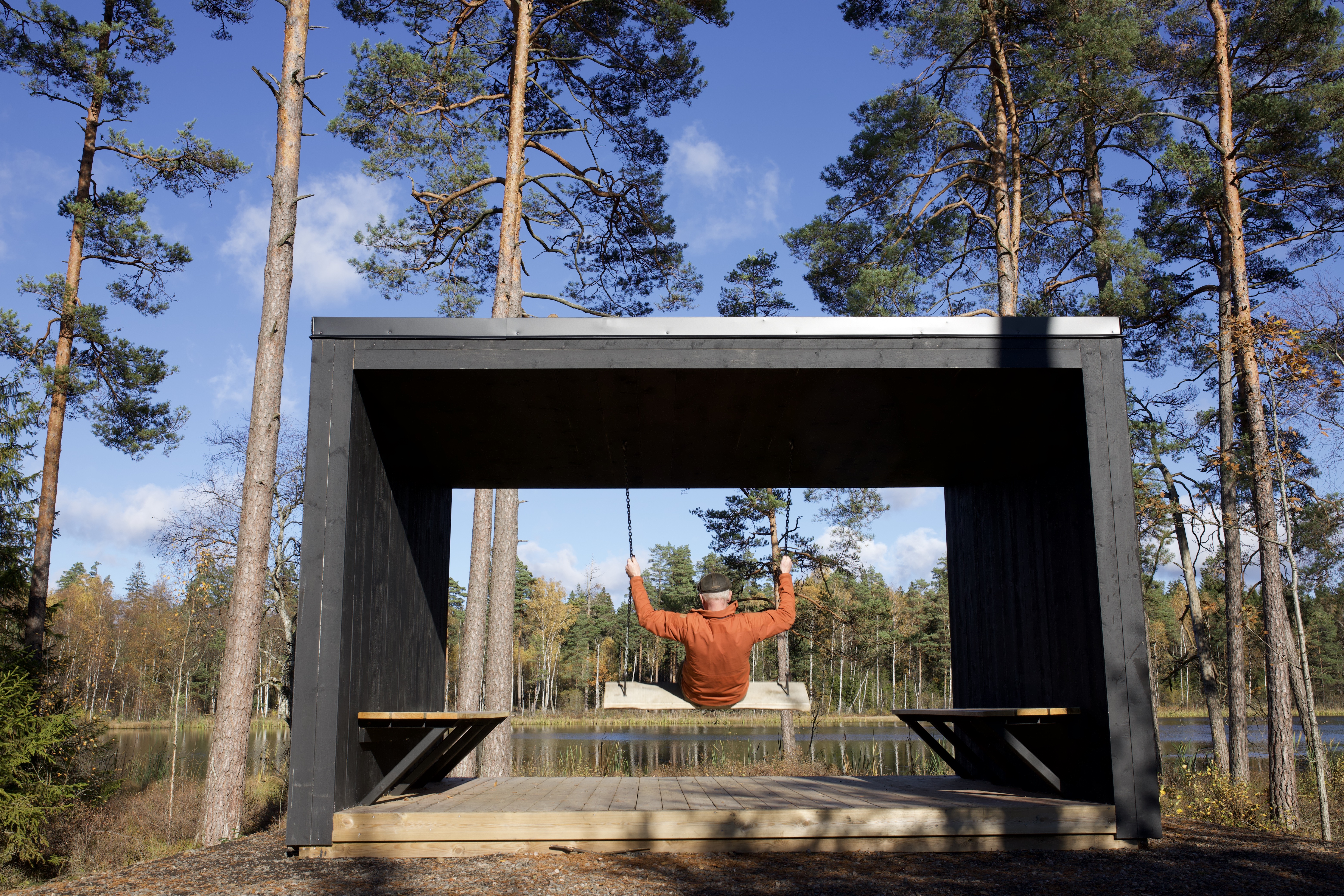 En person gungar i ett vindskydd i skogen